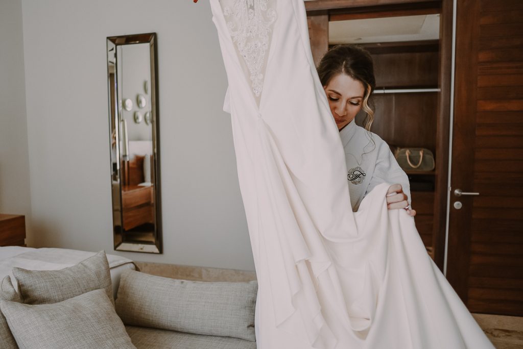 Bride getting into her wedding dress at Heritage Fairmont Mayakoba. Caro Navarro Photography