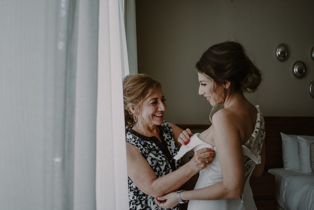 Mother of the bride dressing her daughter at Heritage Fairmont Mayakoba by Caro Navarro Photography