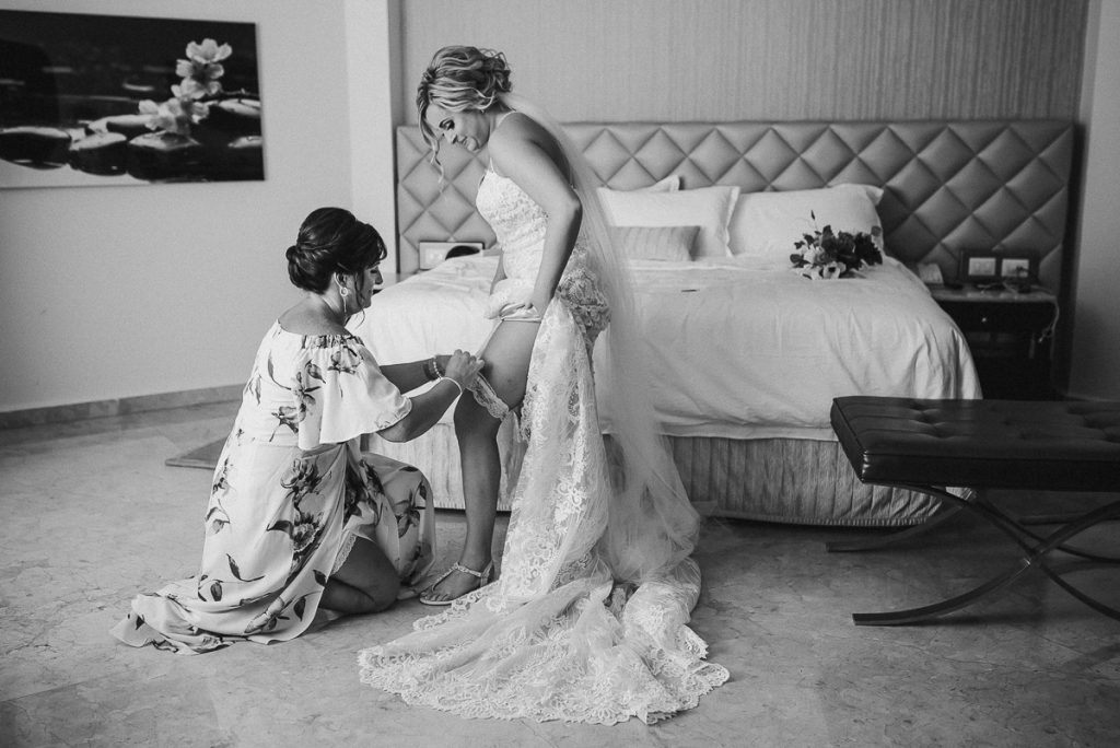 Mother of the bride placer the garter on bride. Moon Palace Wedding by Caro Navarro Photography