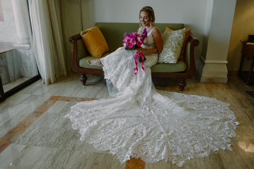 Bride with long tail wedding dress and hot pink bouquet at Now Sapphire Riviera Cancun. Caro Navarro Wedding Photography