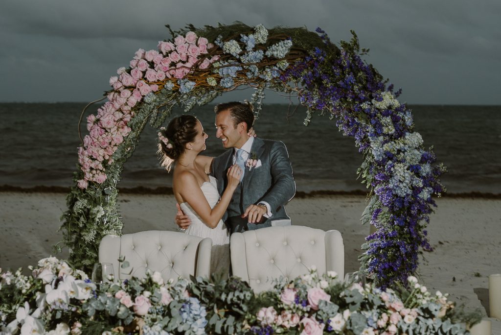 Beach wedding reception at Jardin del Mar, Riviera Maya with round floral arch. Caro Navarro Photography