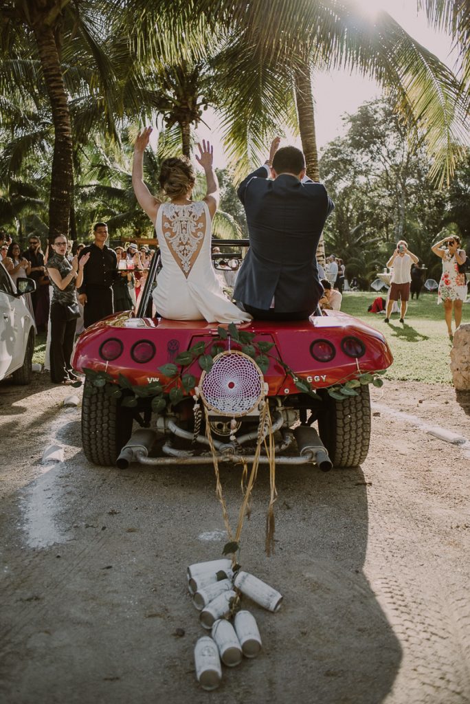 Bride and groom reception entrance in red buggy. Caro Navarro Mexico Wedding Photography