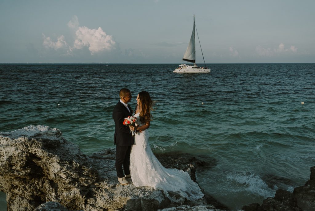 Bride and groom portraits with sailboat. Riu Caribe Cancun wedding by Caro Navarro Photography