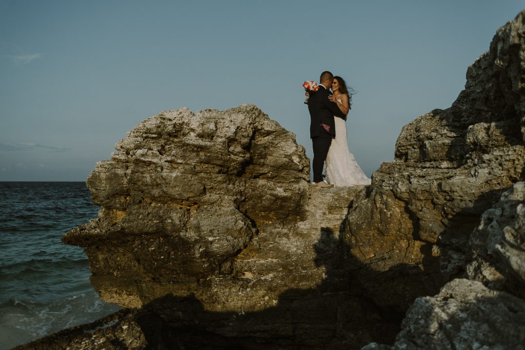 Bride and groom cliff portraits. Cancun destination wedding by Caro Navarro Photography