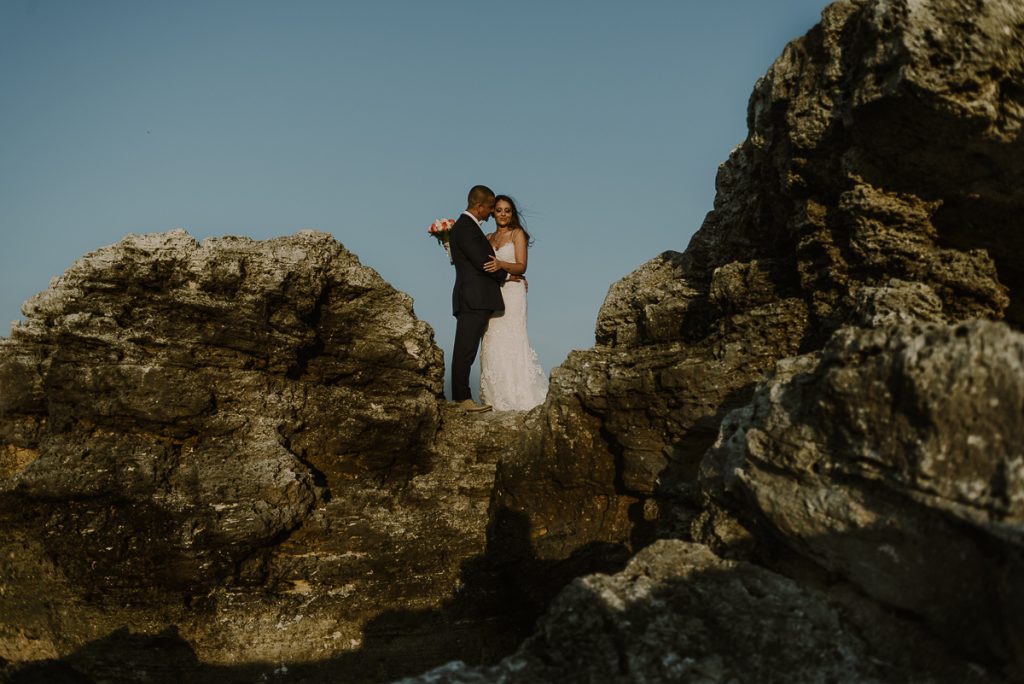 Bride and groom cliff portraits. Riu Caribe Cancun destination wedding by Caro Navarro Photography