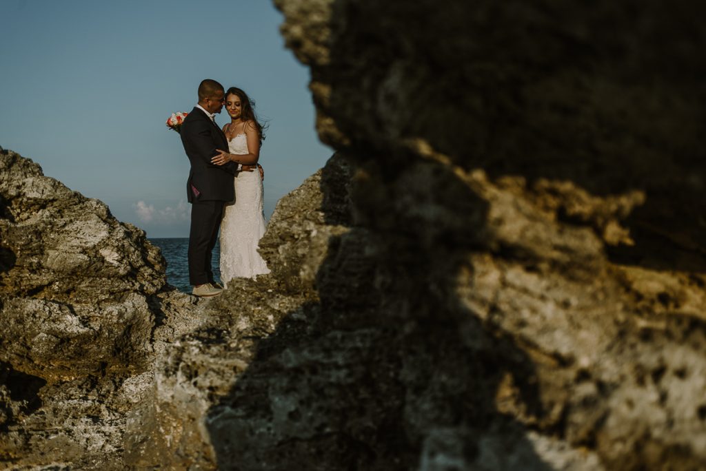 Bride and groom cliff portraits. Riu Caribe Cancun destination wedding by Caro Navarro Photography