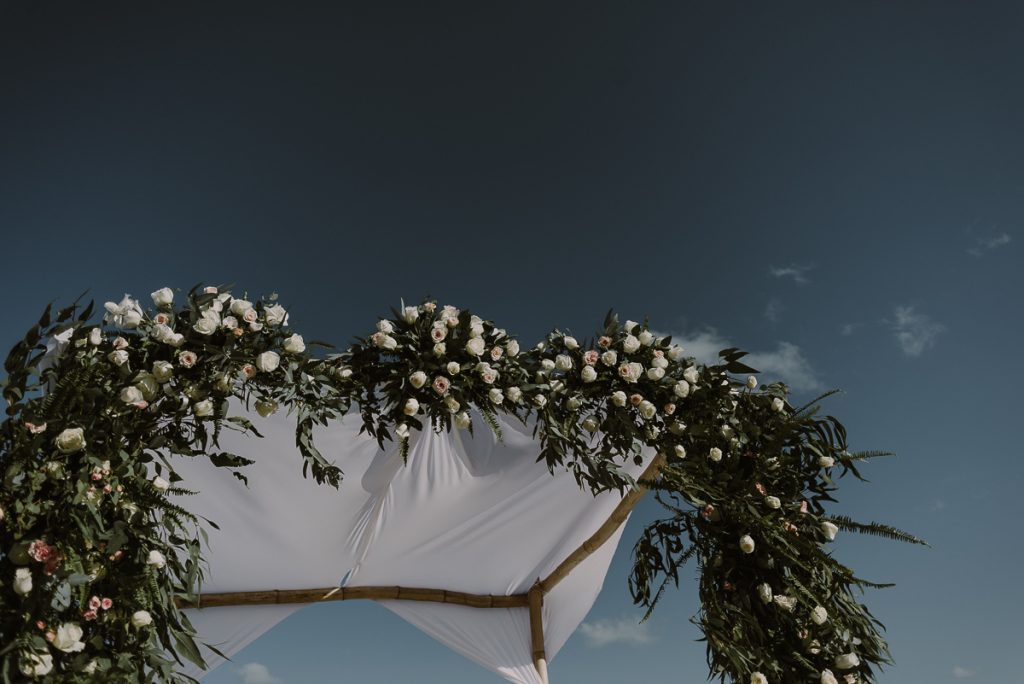 Floral wedding arch at Royalton Riviera Cancun, Mexico. Caro Navarro Photography