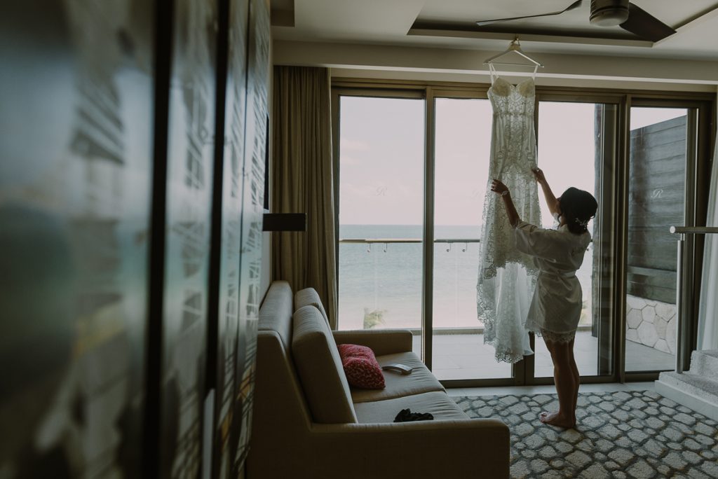 Bride and wedding dress hanging. Royalton Riviera Cancun. Caro Navarro Photography