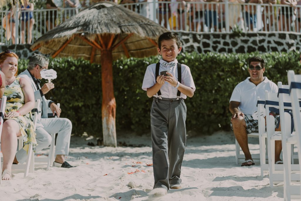 Ring bearer walking down the aisle at Riu Caribe Cancun Wedding by Caro Navarro Photography