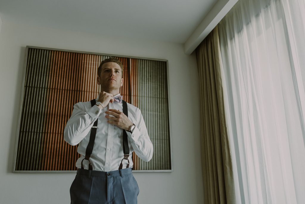 Groom fixing bow tie at Royalton Riviera Cancun Wedding by Caro Navarro Photography