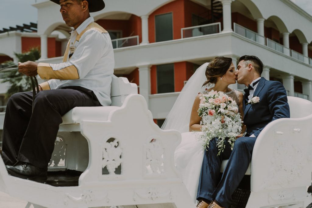 Bride and groom on horse carriage at Hard Rock Riviera Maya. Caro Navarro Wedding Photography